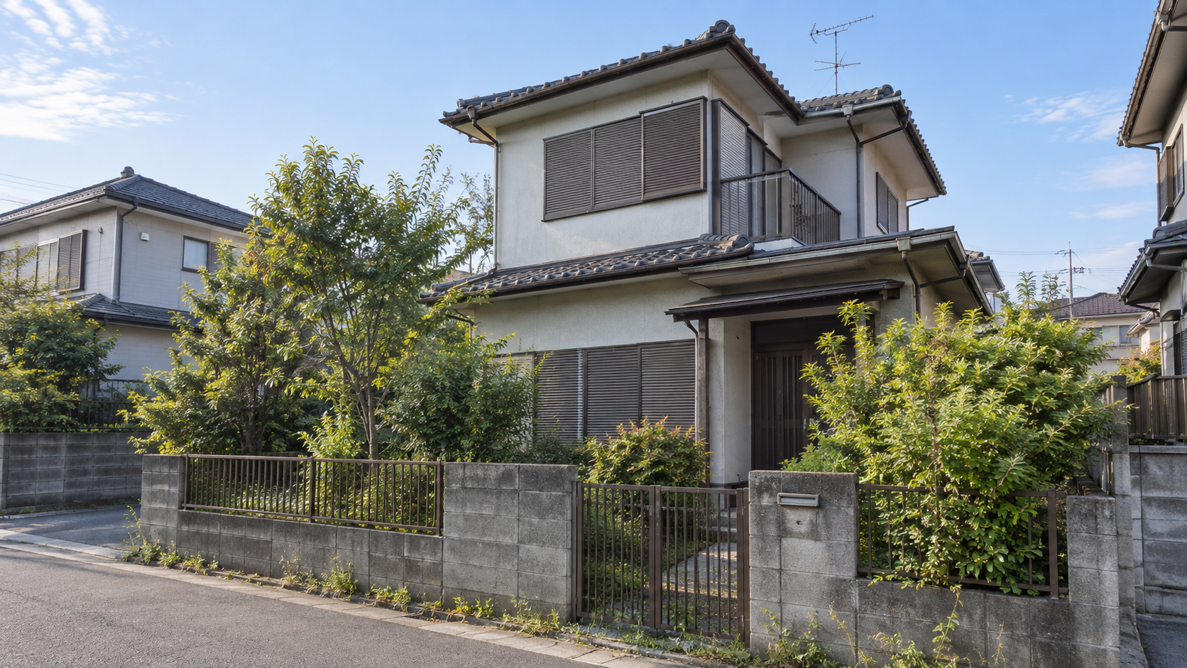 庭木が伸びた住宅地の空き家を写したイメージ画像